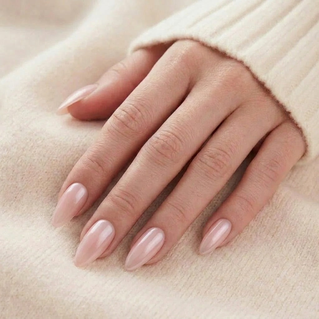 Pinkie Pearl press-on naglar i glansig mjölkig rosa-nude med pärlemorsken på long almond-naglar mot beige stickad tröja