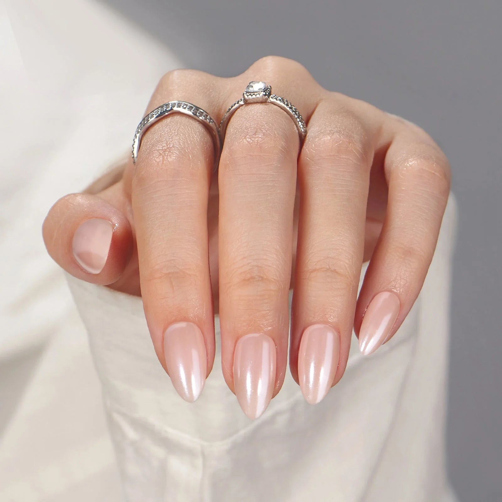 Heavenly Halo press-on naglar närbild – glansig pearl finish med silverringar och vit blus