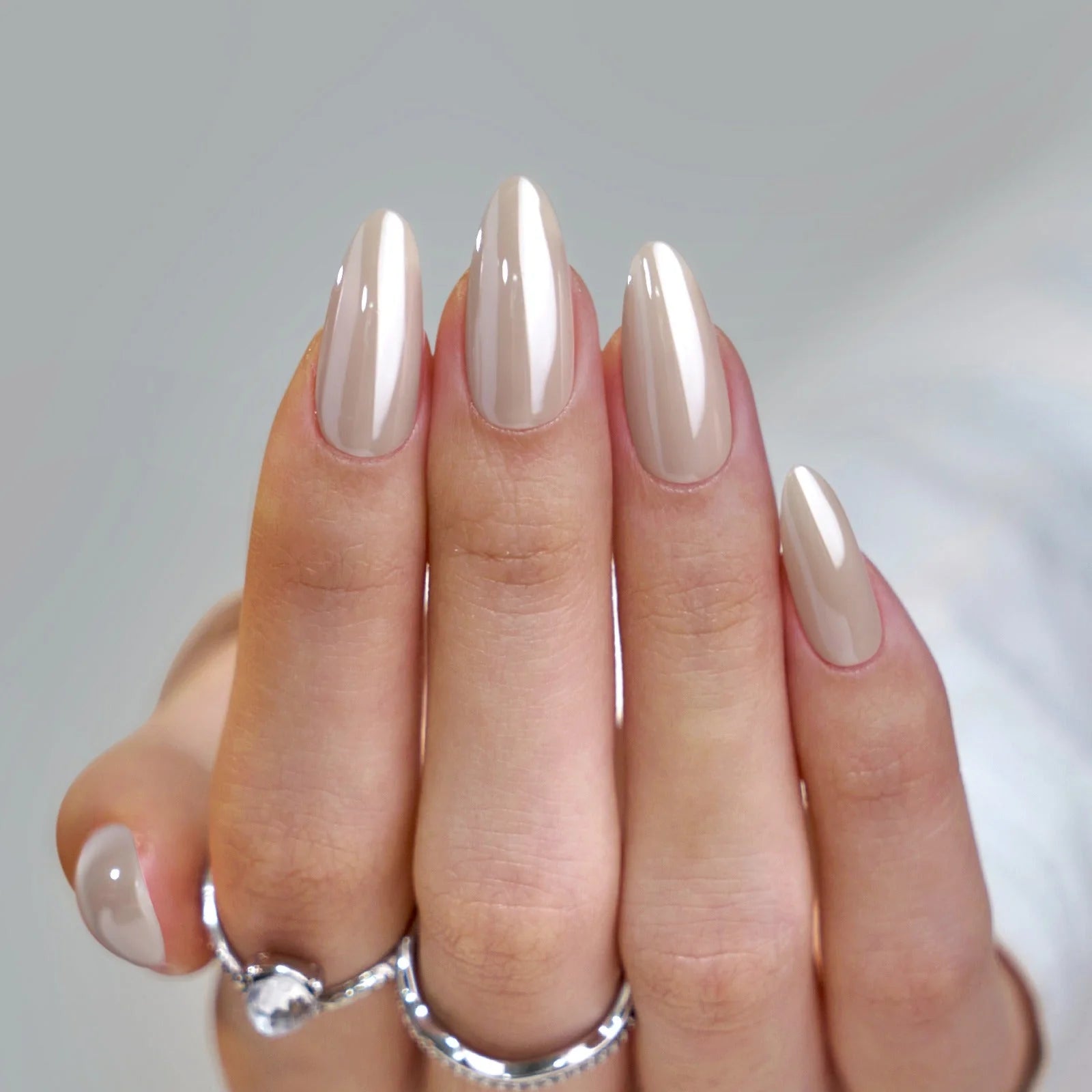Mandelformade lösnaglar med pärlglans – Pearly Perfection i taupe nude med silverringar