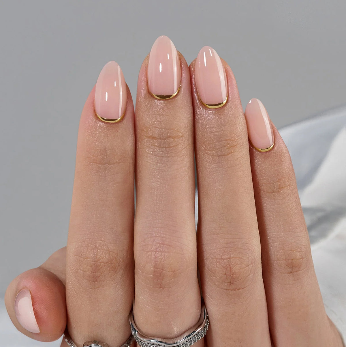 Golden Glimmer press-on naglar närbild – nude bas och guld linje längs cuticle
