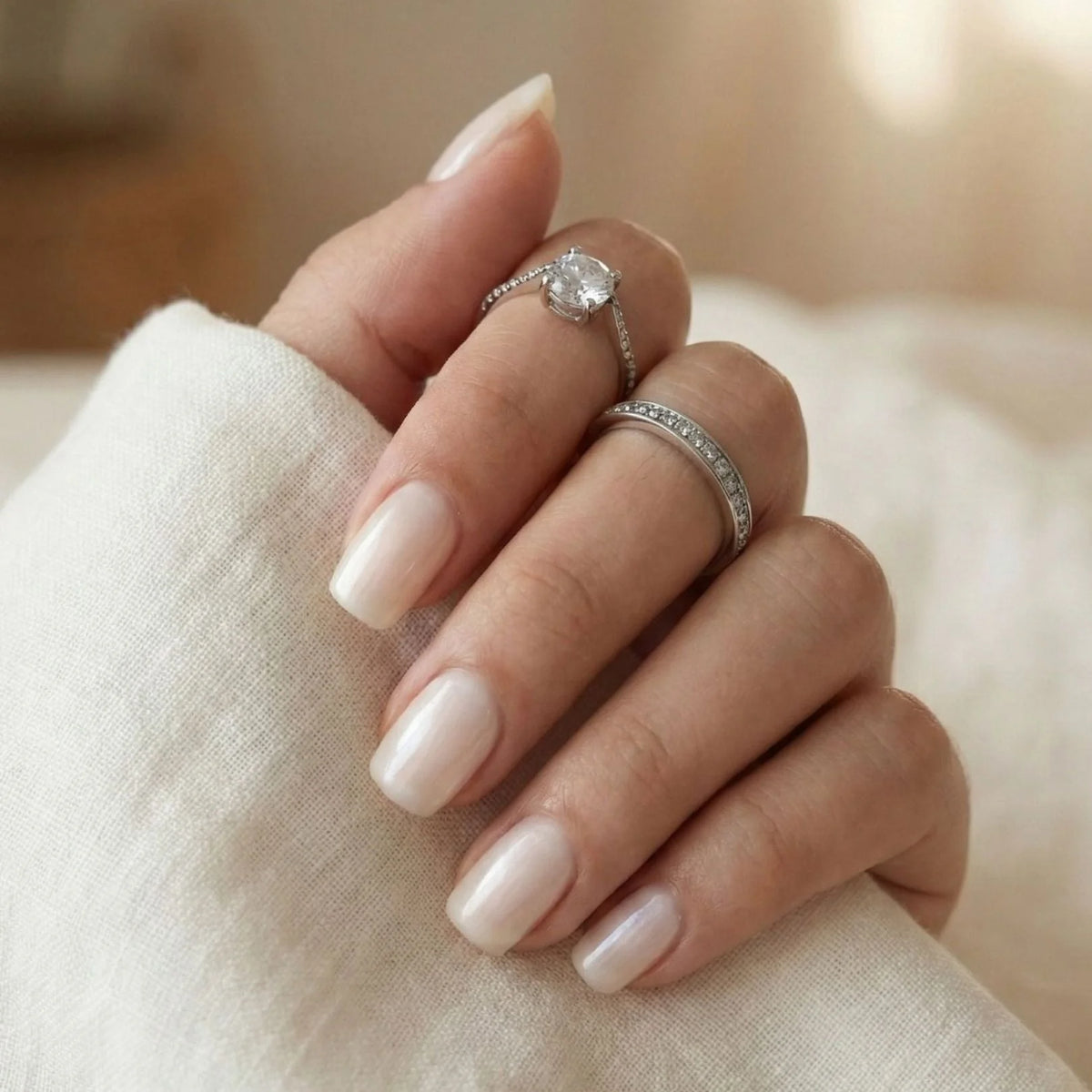 Pure Pearl gelénaglar närbild – kort square i vit pearl med vit blus och silverringar